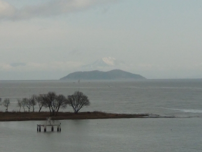 琵琶湖大橋西詰めから眺めた北湖。沖島の向こうに冠雪した伊吹山がくっきりと見えます。沖のど真ん中で釣り中のボートも見えます（1月15日9時20分頃）