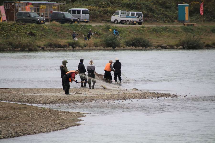 中州に網を引き揚げる漁師たち